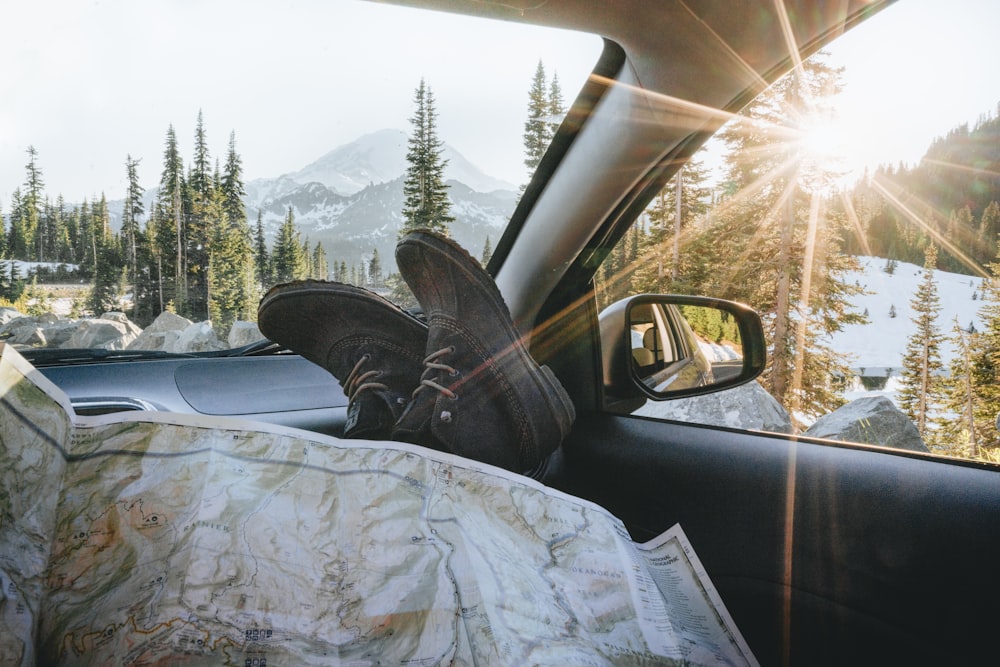 person in black leather boots sitting inside car