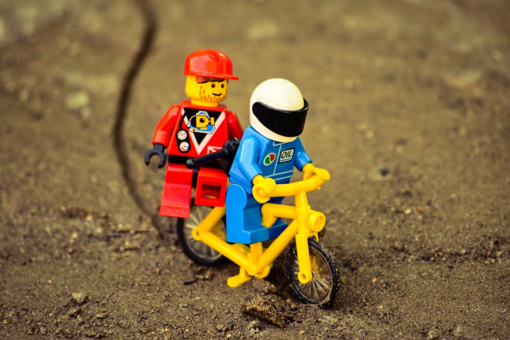 lego mini figura montando bicicleta amarela