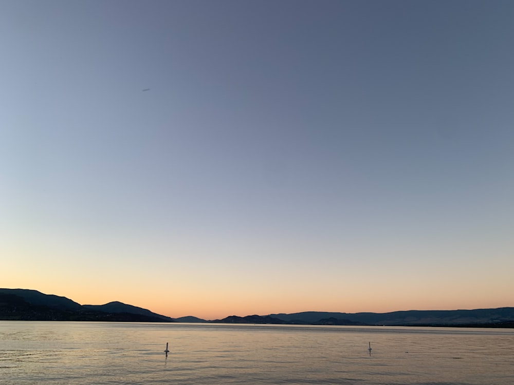 silhouette of boat on sea during sunset