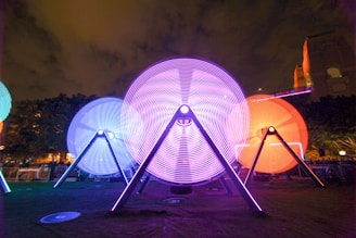 A glowing neon spiral installation wrapping around the San Michele bell tower at dusk.