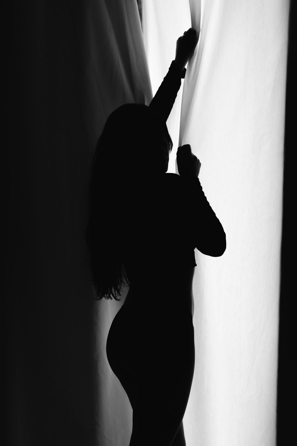 silhouette of woman standing near wall