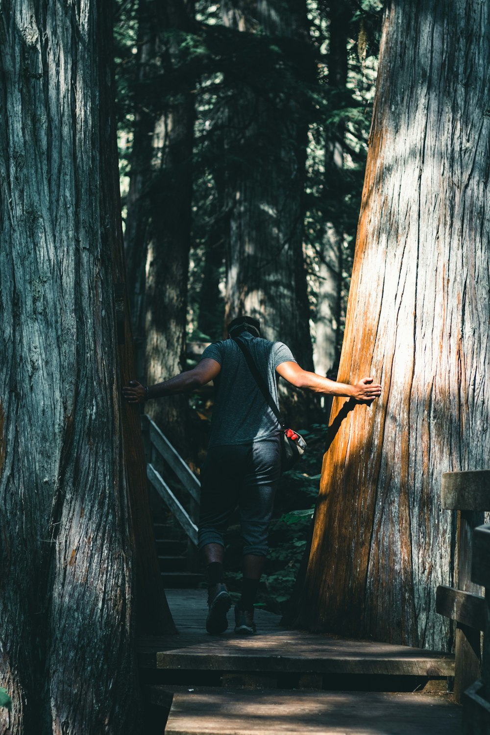 man in black t-shirt and black pants sitting on wooden stairs