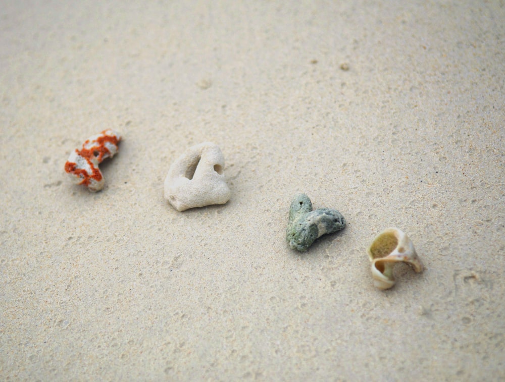 white and red heart shaped stones on white sand