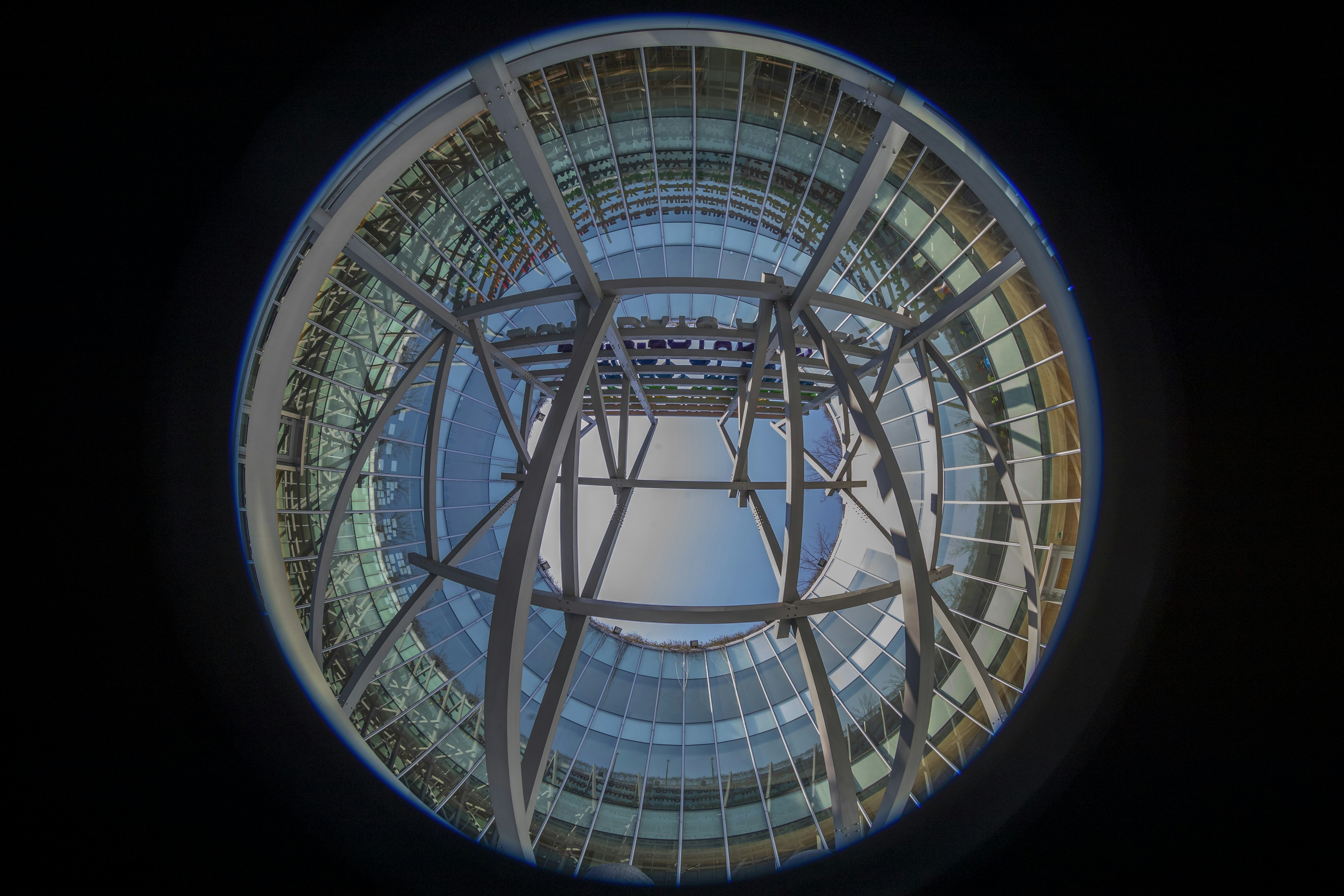 Large custom fiberglass dome installation against blue sky, architectural landmark, bright natural lighting, upward angle view