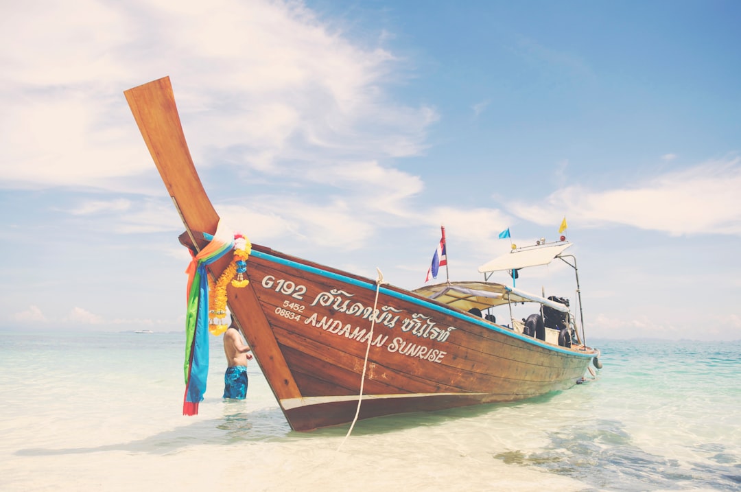 brown and white boat on white sand during daytime