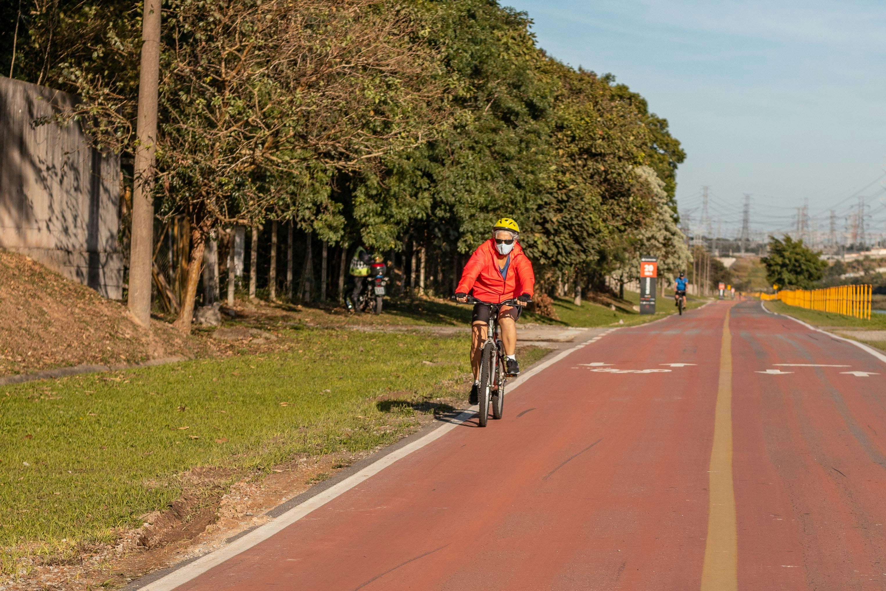 man in yellow shirt riding bicycle on road during daytime