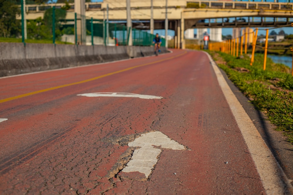 brown concrete road near green trees during daytime