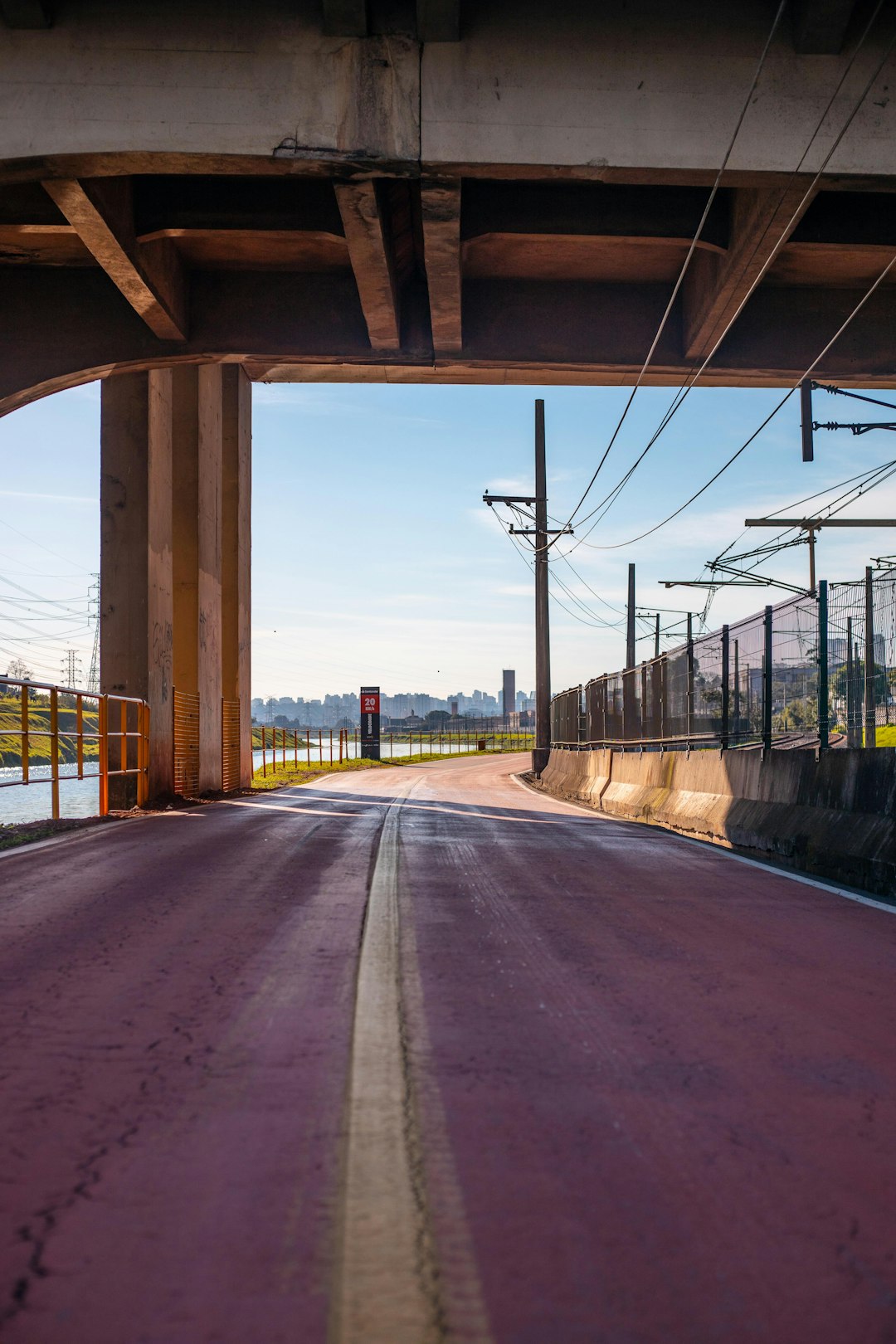 gray concrete road near body of water during daytime