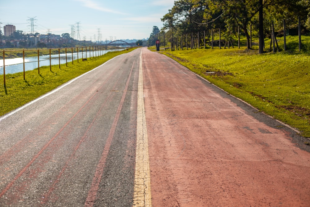 brown dirt road between green grass field during daytime