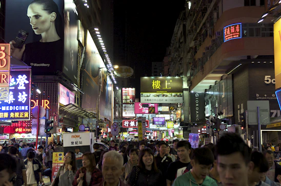 A vibrant city street at night with glowing storefronts and animated deal badges floating above shops.