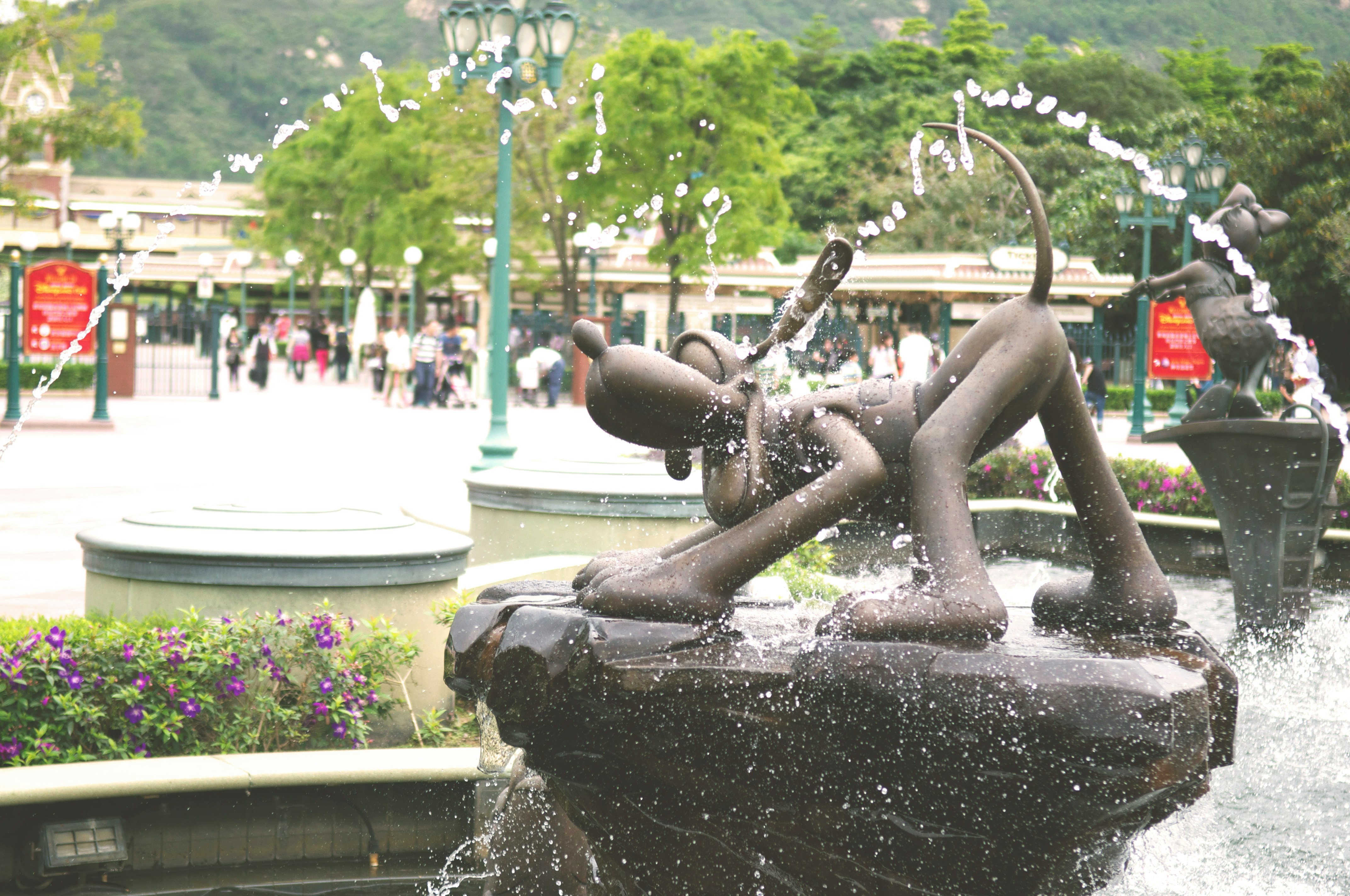 people sitting on water fountain during daytime