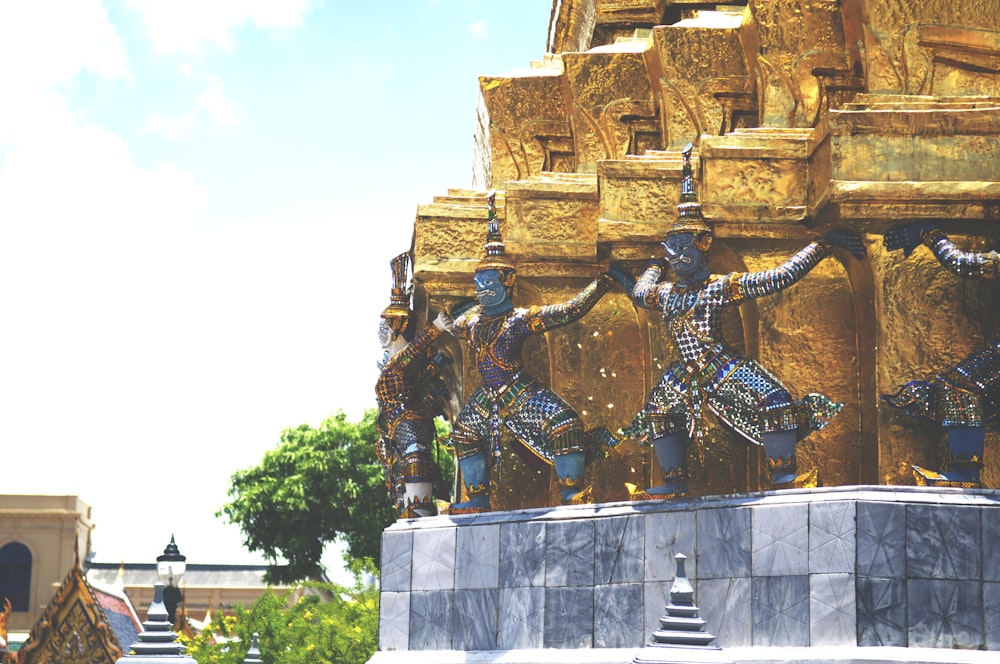 gold and black statue of man on top of building
