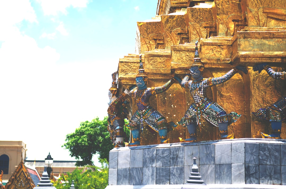 gold and black statue of man on top of building