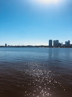 A serene Miami coastline at sunrise with modern high-rise condos reflecting soft teal hues.