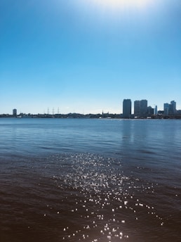 A serene Miami coastline at sunrise with modern high-rise condos reflecting soft teal hues.