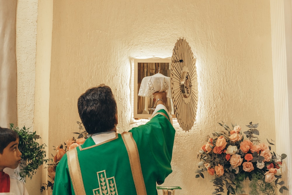 man in green and white shirt standing near wall