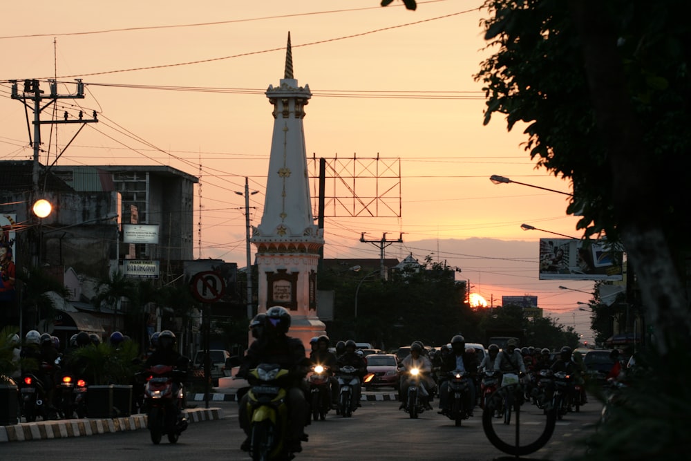 people riding motorcycle on road near white concrete building during daytime