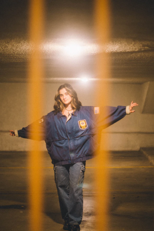 A creator showing off a jacket in a parking garage