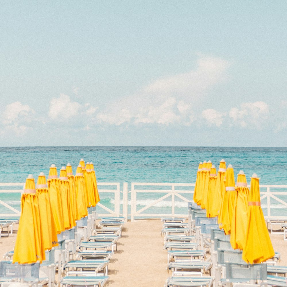 white wooden chairs on beach during daytime