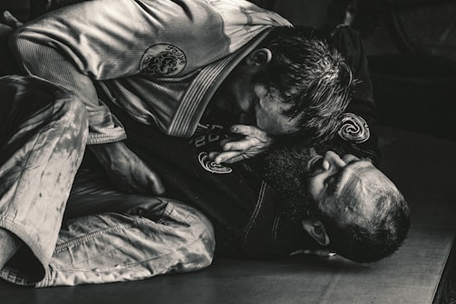 Close-up of a jiu jitsu competitor expertly applying a submission hold during a heated tournament match.