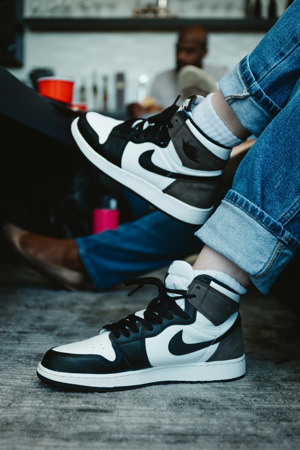 person wearing black and white nike sneakers