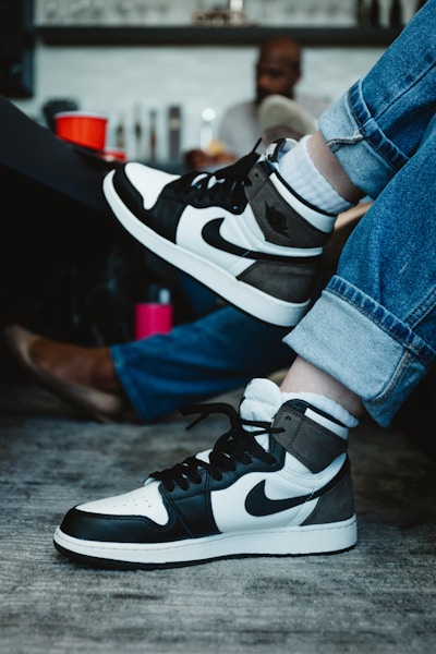 person wearing black and white nike sneakers
