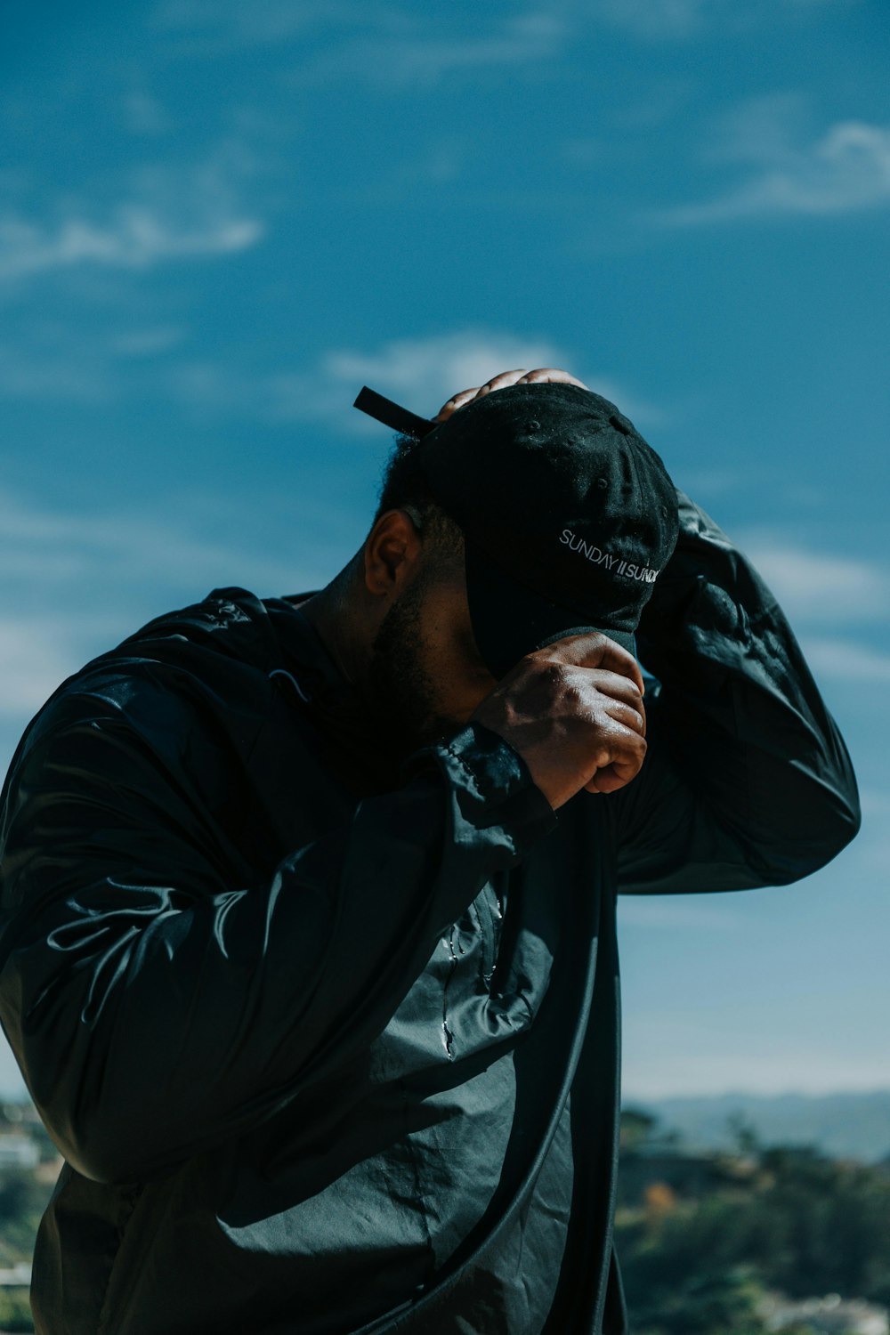 man in black leather jacket and black fitted cap