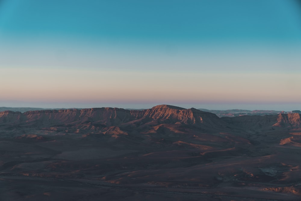 Montañas marrones y negras bajo el cielo azul durante el día