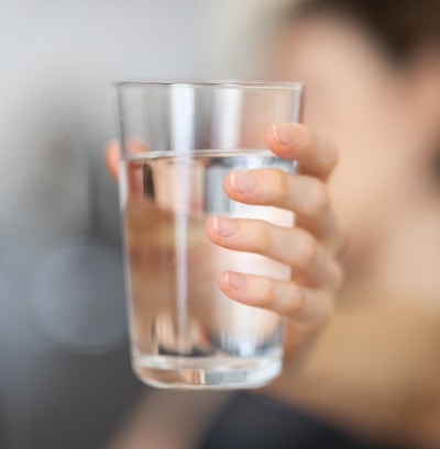 person holding clear drinking glass