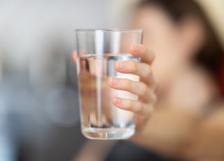 person holding clear drinking glass