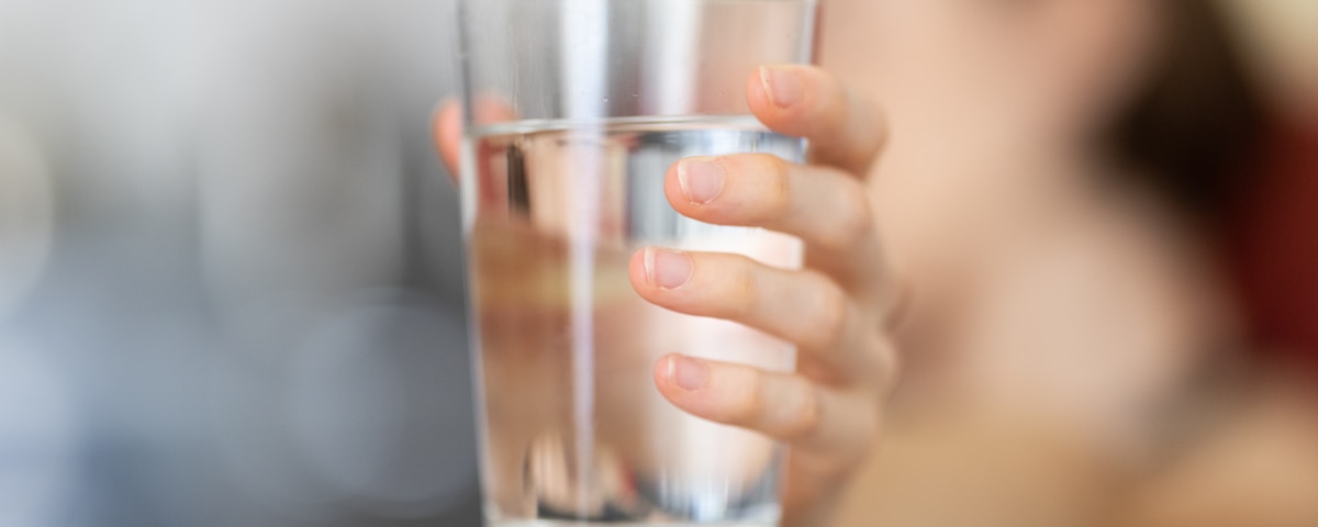 person holding clear drinking glass