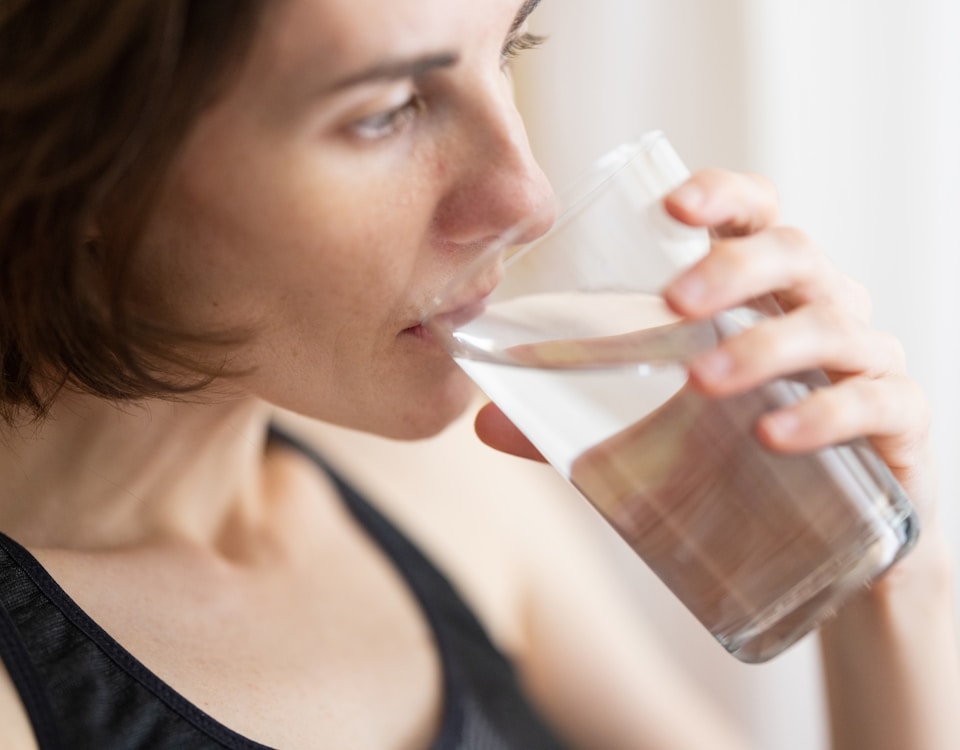 woman in black tank top drinking water