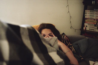 woman in black shirt lying on bed