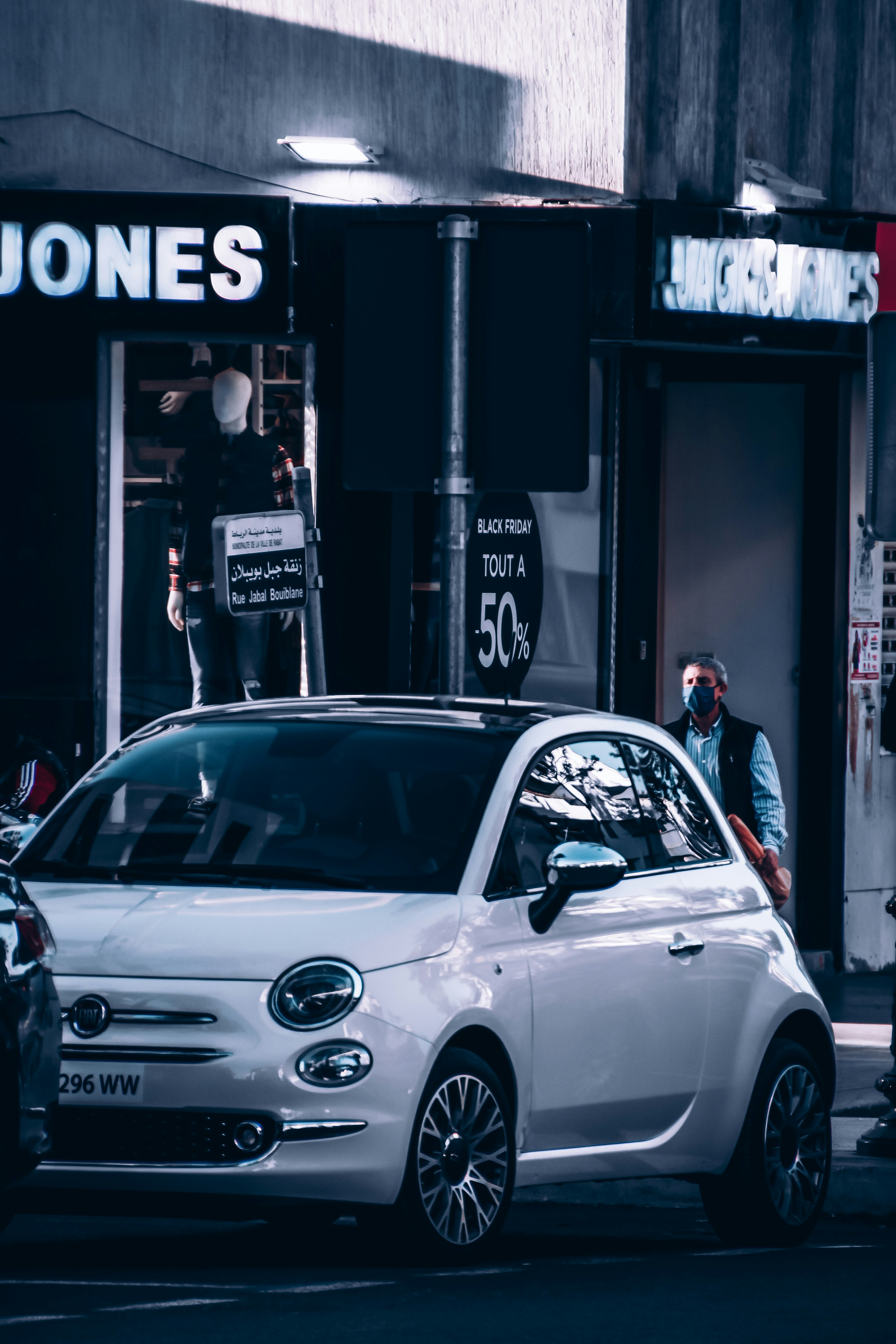 white sedan parked beside black and white building