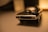 Close-up of a sleek metallic diecast car model with reflective surfaces under soft lighting.