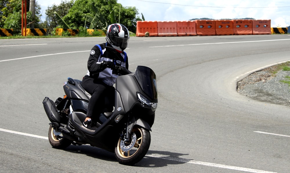 man in black helmet riding black sports bike on road during daytime