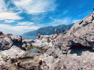 a group of people standing on top of a rocky cliff