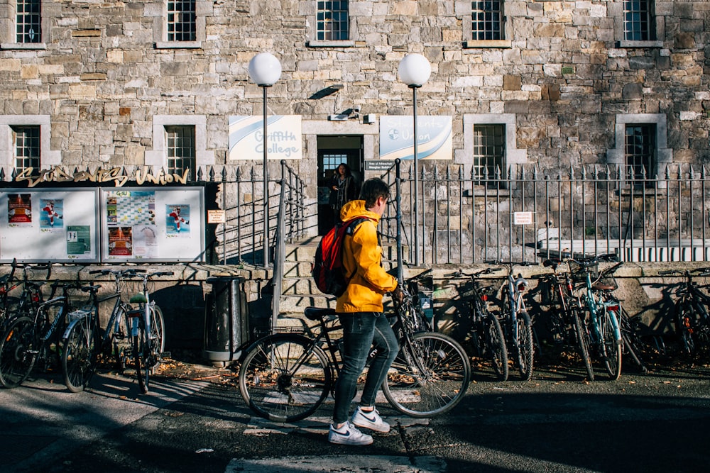 man in yellow jacket riding bicycle