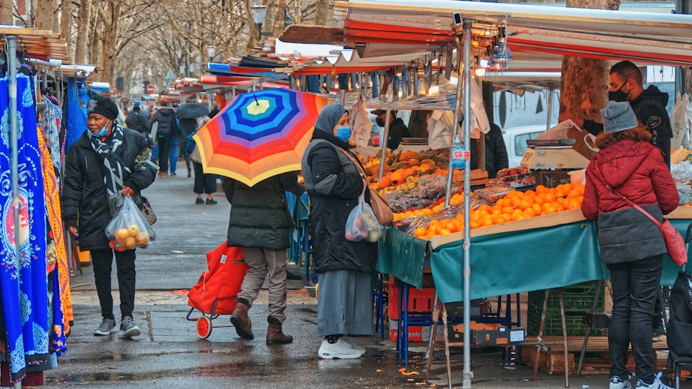 people walking on street with umbrella during daytime