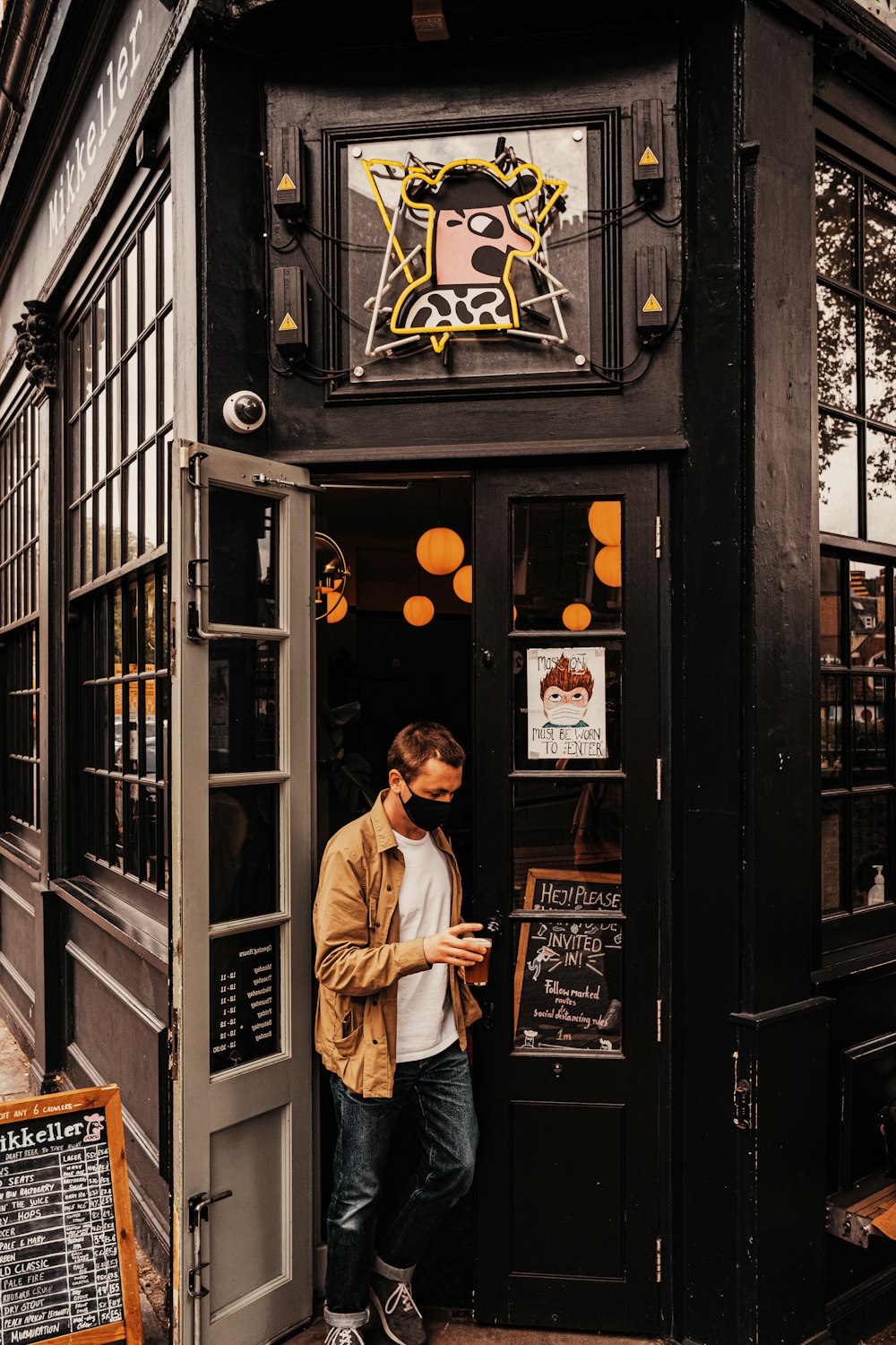 man in white dress shirt and black pants standing in front of store