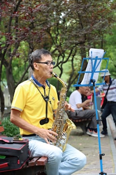 man in yellow crew neck t-shirt playing saxophone