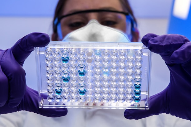 A scientist in a lab coat carefully examining cosmetic formulations under bright laboratory lights.