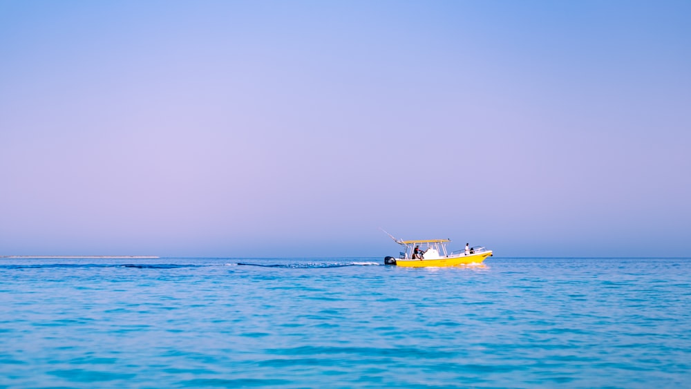 yellow and white boat on sea during daytime