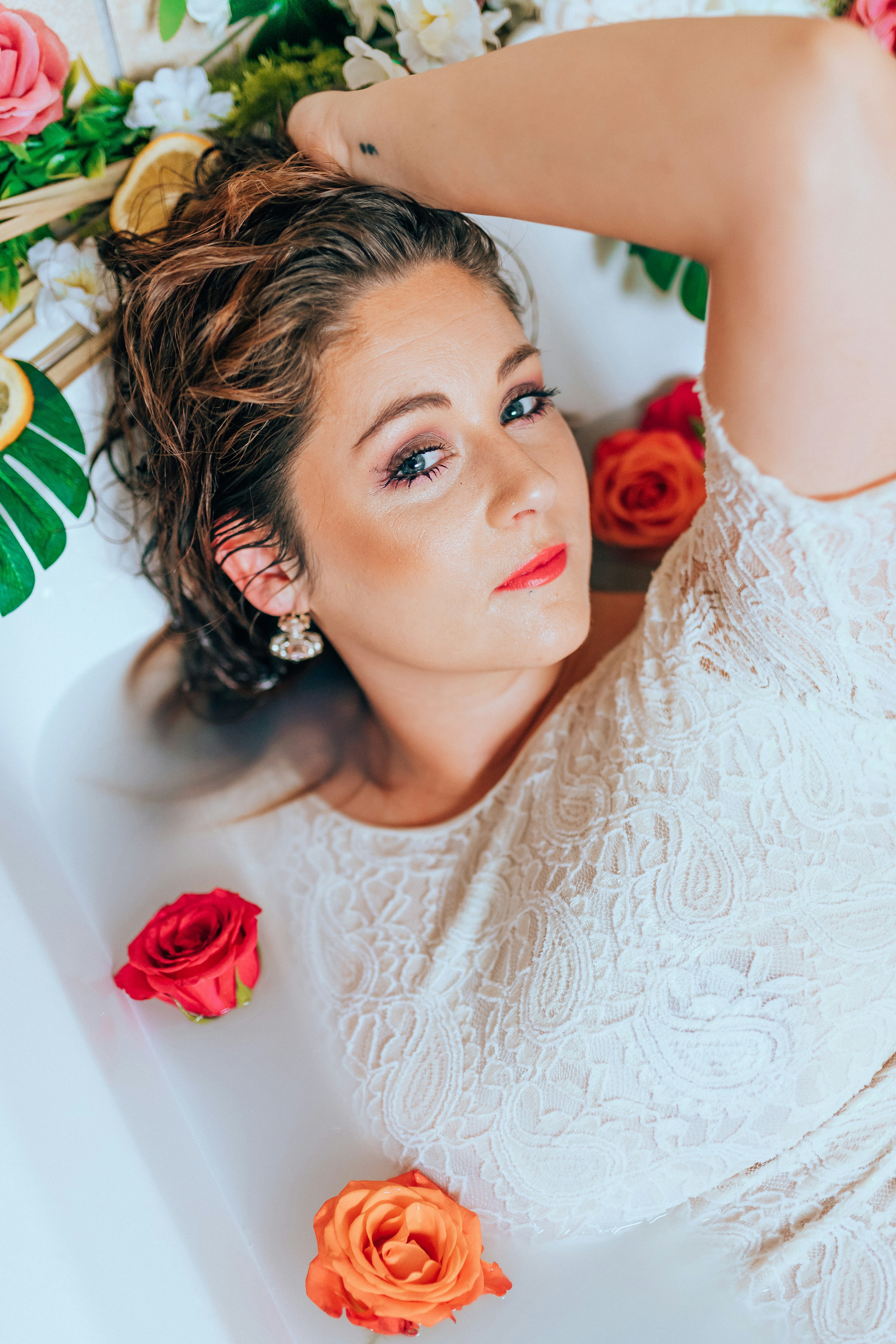 woman in white lace floral lace shirt lying on white ceramic bathtub