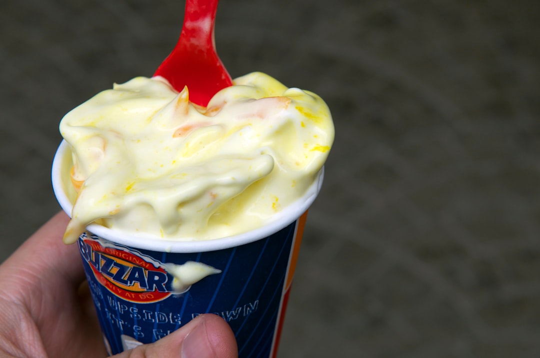 person holding blue and white ice cream cup