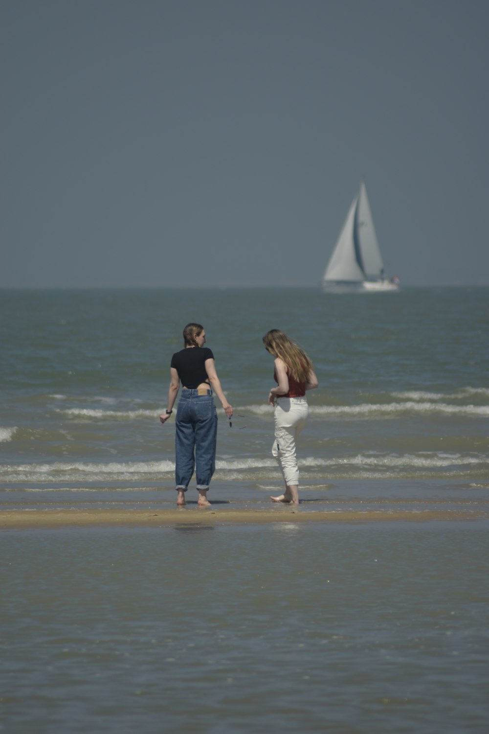 couple walking on beach during daytime