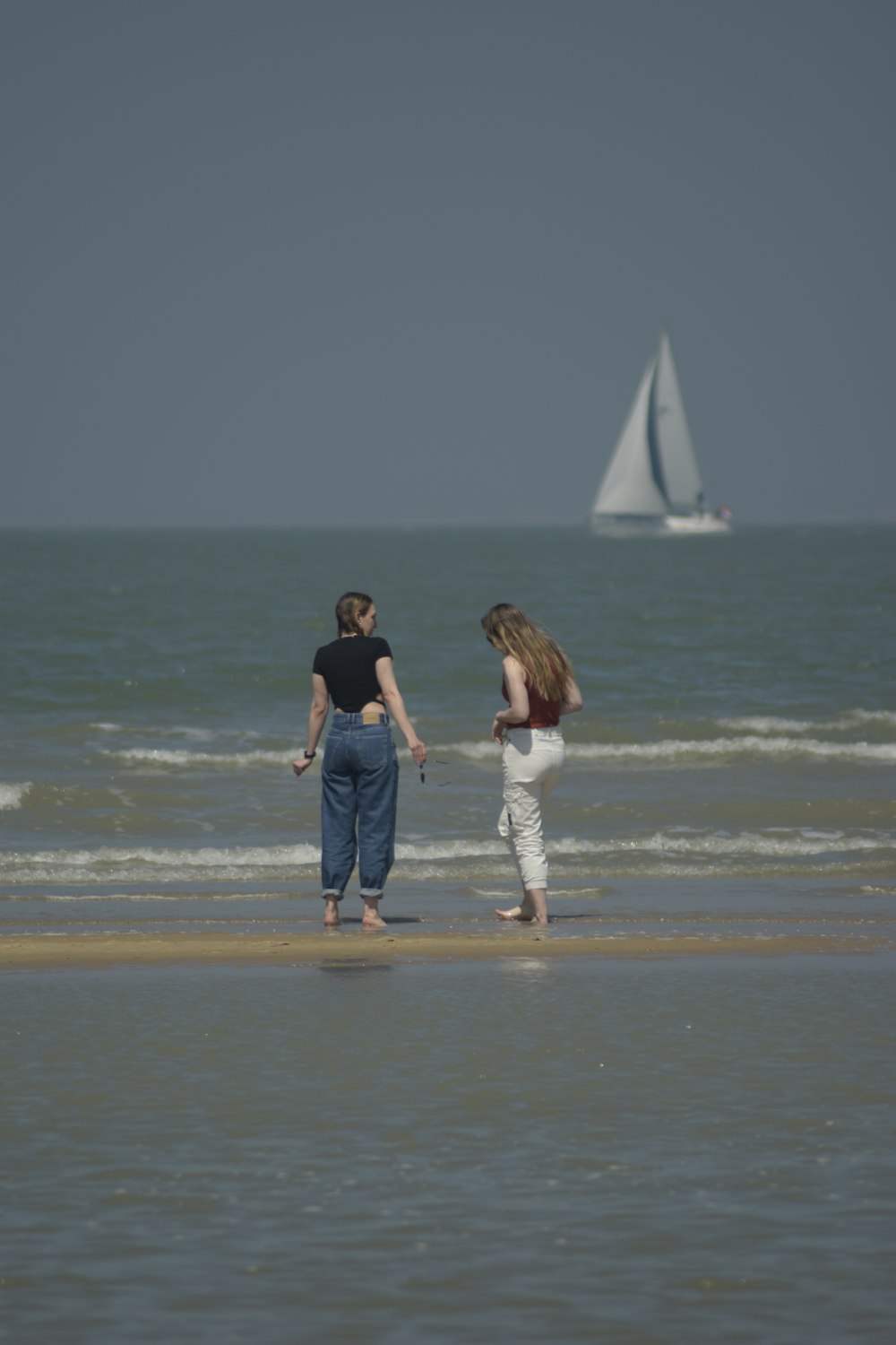 casal andando na praia durante o dia