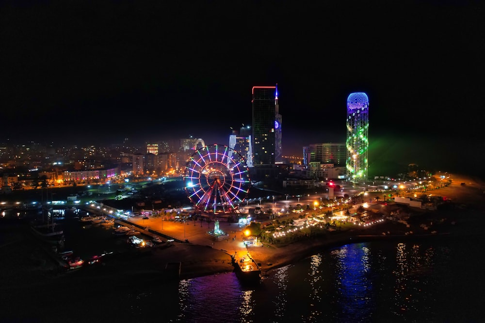 Grande roue près d’un plan d’eau pendant la nuit