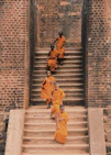 man in yellow jacket walking on gray concrete stairs