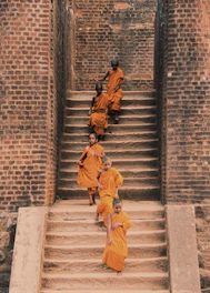 A group of young members warmly welcoming a new member in saffron attire.